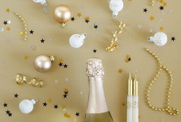 Happy new year 2021 with champagne and  decorations in gold colors on gold background. Top view. Christmas card.