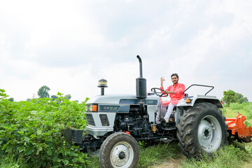 Indian farmer working with tractor at field