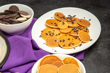 front view delicious little pancakes with cookies on dark desk milk dessert sweet