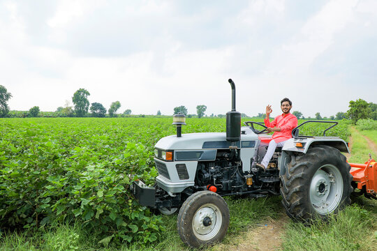 Indian farmer working with tractor at field