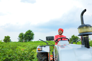 Indian farmer working with tractor at field