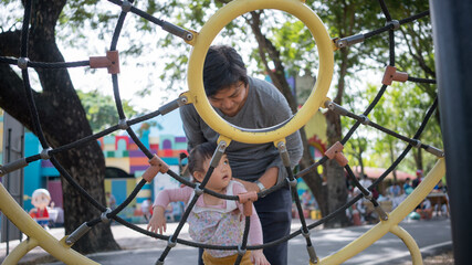 Happy Family concept, Selective focus, Quality Family Time Father takes care little daughter playing at the playground.