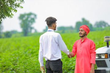Banker and farmer negotiating bank agriculture loan in field