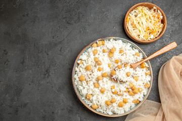 Horizontal view of peas and rice dish for dinner with a spoon and sauerkraut towel on dark table