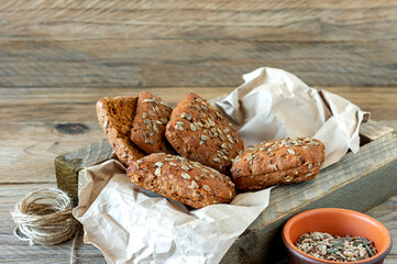 Closeup of multigrain or whole grain bread rolls in a cloth lined in wooden box.