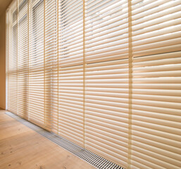 Motorized wood blinds in the interior. Automatic venetian blinds beige color on large windows....