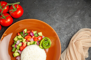 Horizontal view of vegan dinner with rice and different types of vegetables on dark table
