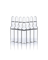 Set of transparent glass ampoules with liquid on a white background.