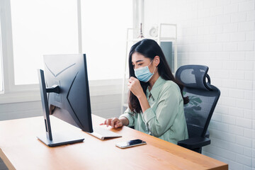 Beautiful Asian business woman work at home modern office, wearing medical face mask coughing, protection from COVID-19 pandemic smart plan strategies using computer internet networking technology
