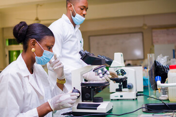 two young african health care researchers working in life science laboratory about the cure of the...
