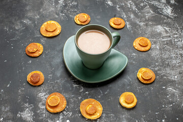 Close up view of delicious pancake around the a cup of coffee on gray background