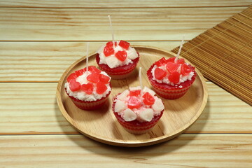 Pile of beautiful cupcake made from candle on the wooden plate. Famous souvenir and present in ceremony or festival. 
