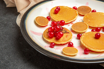 front close view little pancakes with red berries on dark background sweet cake milk