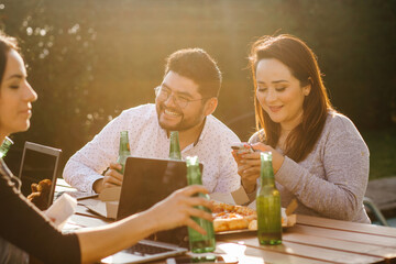 Latin friends drinking beer and working at terrace in Mexico city