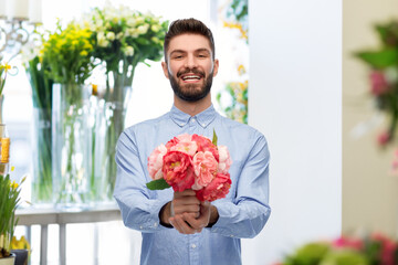 international women's day and greeting concept - happy smiling man with bunch of peonies over flower shop background