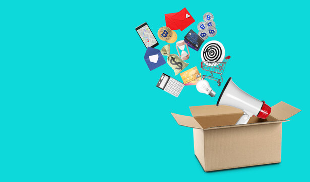 Open cardboard box with different items on color background. Concept of digital marketing