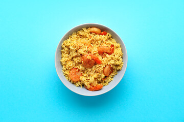 Plate with tasty pilaf on color background