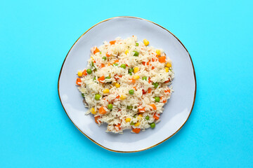 Plate with tasty pilaf on color background