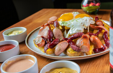 Salchipapa Frankfurt con papas fritas y huevo frito montado
