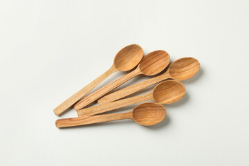 Empty wooden spoons on white background, top view
