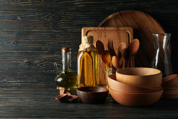 Different wooden kitchenware on wooden table, space for text