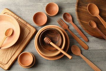 Different wooden dishes on gray table, top view