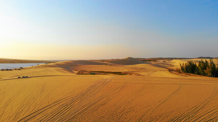 Aerial view of Bau Trang lake (raw of automobiles with blue sky in desert, beautiful landscape of white sand dunes), the popular tourist attraction place in Mui Ne, Vietnam.