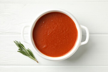 Bowl of tasty tomato soup on wooden background