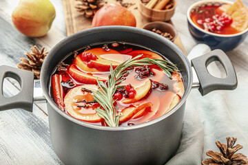 Saucepan with hot mulled wine on table