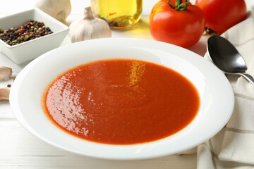 Concept of tasty dinner with tomato soup on wooden background