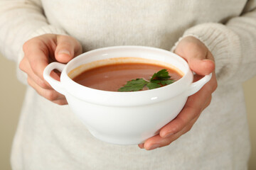 Woman hold bowl of tasty tomato soup, close up