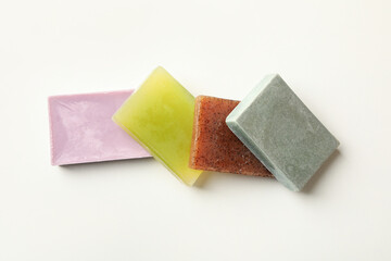 Different pieces of natural soap on white background