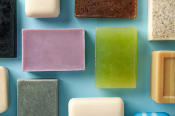 Different natural soap on blue background, top view