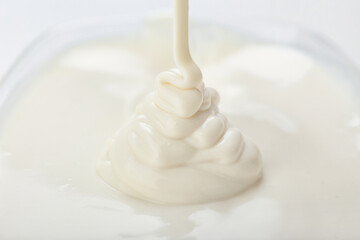 Liquid white chocolate on white background