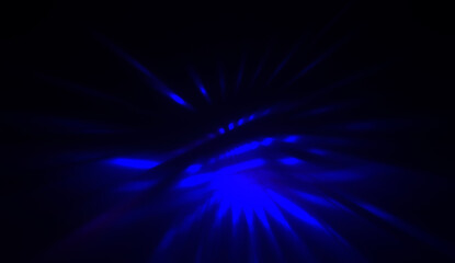 Fototapeta premium Light particles in motion, creating a burst of glowing multicolored rays on a black background. Energetic glow lights wallpaper.