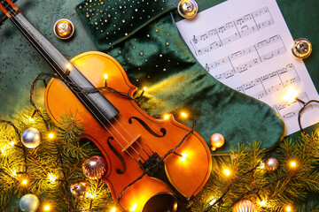 Violin with Christmas lights and music notes on dark background