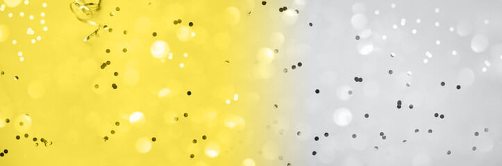 New year, Christmas background. Golden shiny glitter, sparkles, light bokeh on yellow background. Demonstrating trendy Color of the Year 2021. Illuminating Yellow and Ultimate Gray