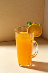 drink, detox and diet concept - glass jug with fruit orange juice and peppermint on table