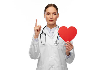 medicine, healthcare and cardiology concept - female doctor with red heart and stethoscope pointing finger up