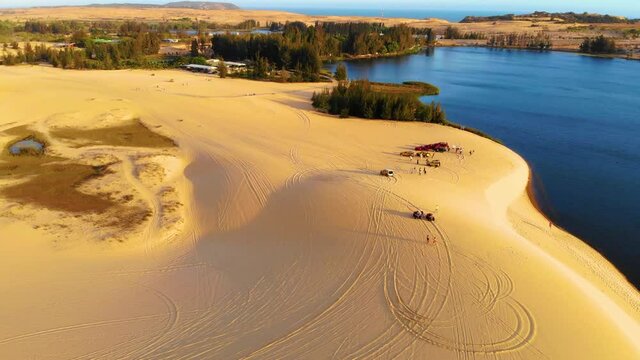 Aerial view of Bau Trang lake (a beautiful landscape, raw of automobiles with blue sky in desert, beautiful landscape of white sand dunes), the popular tourist attraction place in Mui Ne, Vietnam.