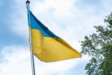 The national yellow and blue flag against sky.