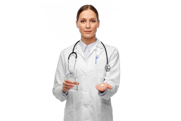 medicine, profession and healthcare concept - female doctor with pill and glass of water over white background