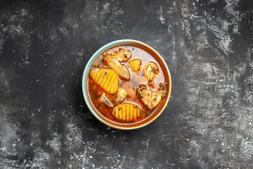 Delicious tomato chicken soup on dark background