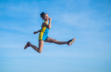 Fototapeta na wymiar cheerful child athlete or gymnast jump on sky background, energy
