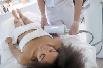 Obraz na płótnie Canvas Calm lying woman and doctor doing procedure