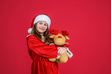 happy christmas child girl wear red santa claus hat and costume play with reindeer toy, toy shop