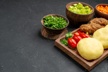 Dinner background with tasty cutlets vegetables and greens on dark background stock image