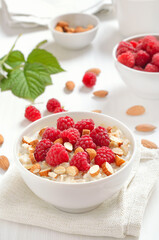 Oatmeal porridge with raspberries and nuts in bowl