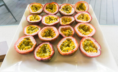 Half cut passion fruits on white plate. Ripe passion fruit isolated on table.