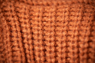 Orange wool scarf background texture. Macro photo with selective focus.